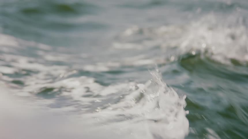 Waves move across the water splashing and sparkling in the sunlight