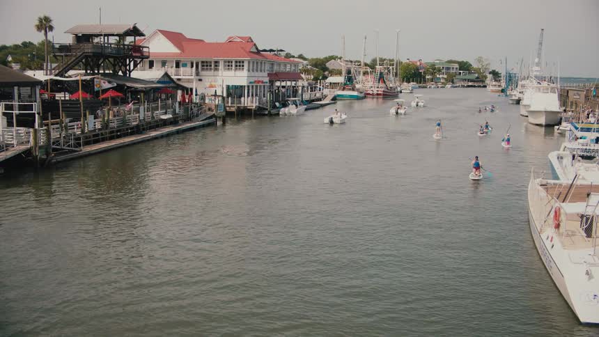 People are paddling on small boats in the marina