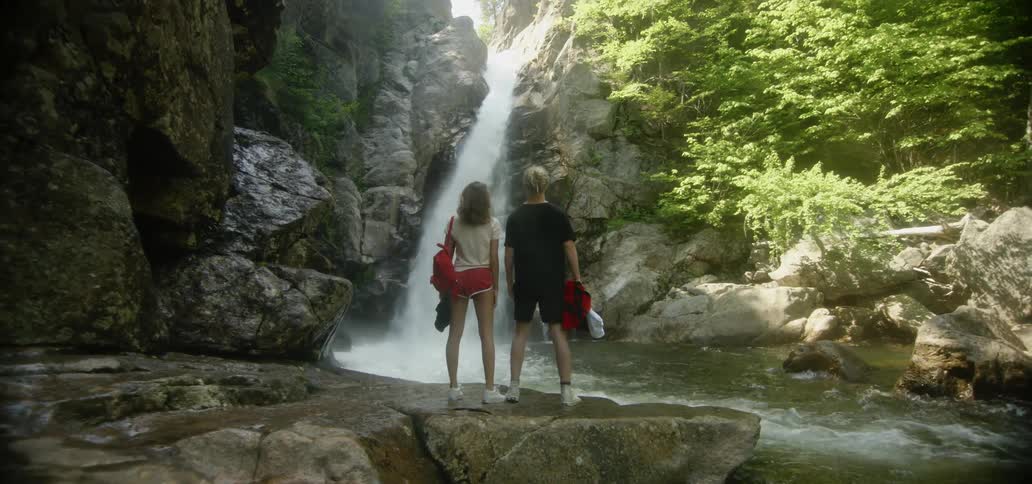 Man and woman look at a waterfall