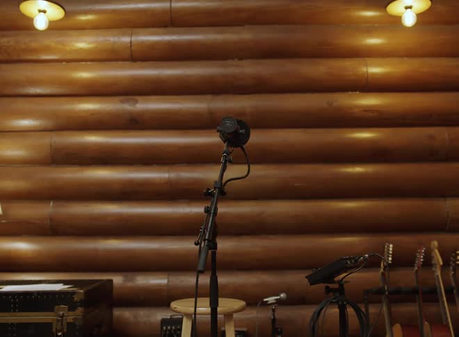 Microphone in a room with guitars leaning against the wall