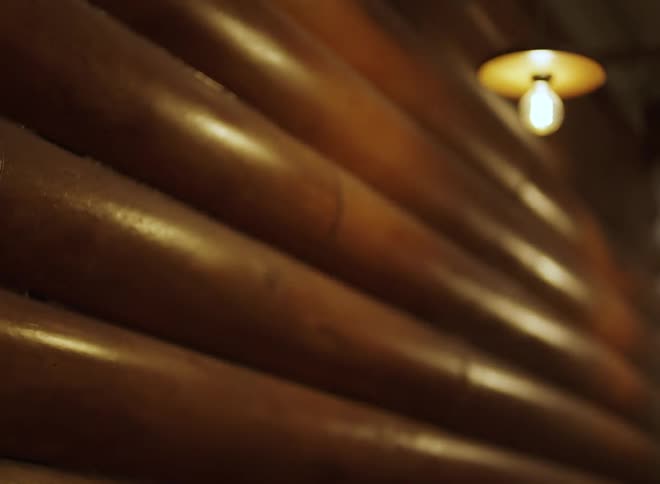 Polished log wall with lit hanging bulb in upper corner