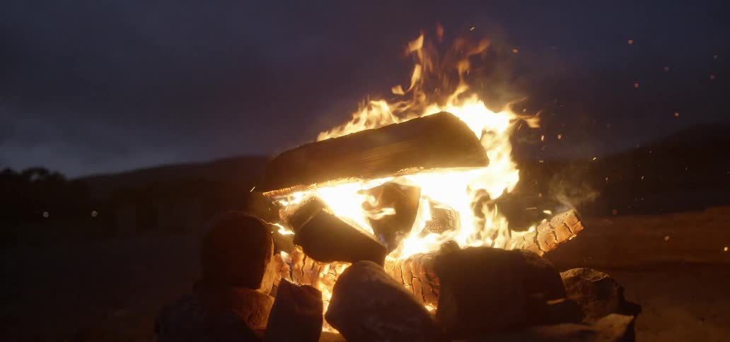 A campfire burns at night