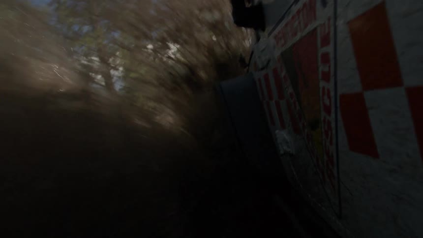 Rescue vehicle splashing through muddy terrain in forested environment