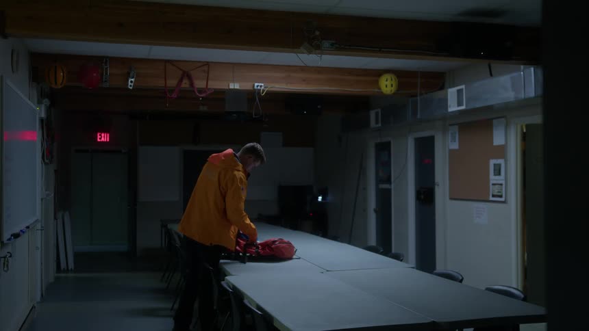 The hiker packs his bag and leaves the room