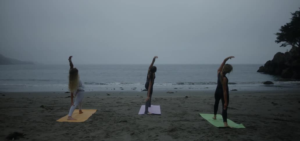 Women do yoga on a beach