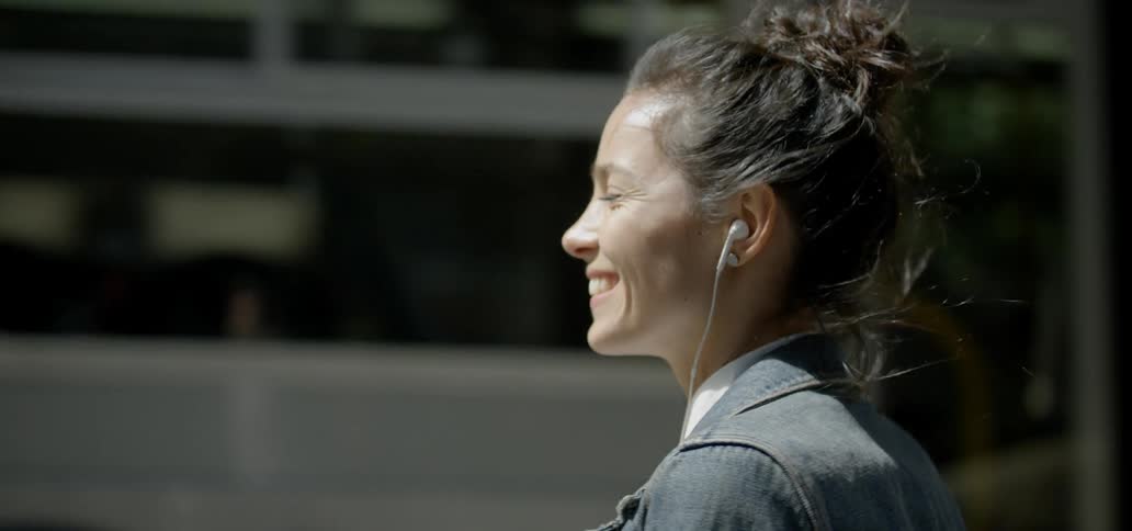A woman turns and smiles as a train passes by