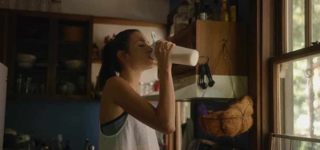 Woman drinks out of a white jug