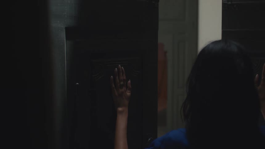 The woman exits the dark room