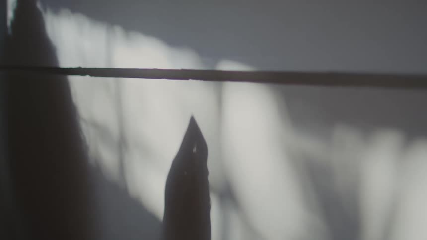 The shadow of the persons hand moves on the wall
