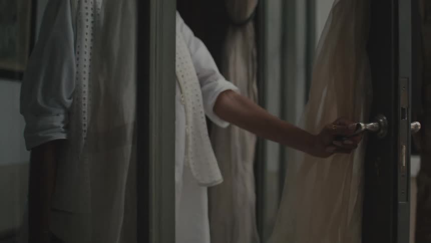 The woman opens the door and walks inside