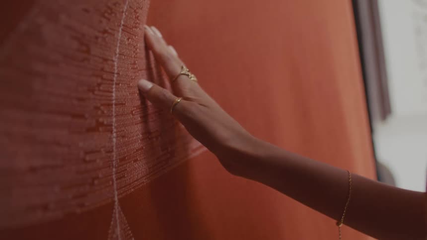 The woman touches the hanging red linen