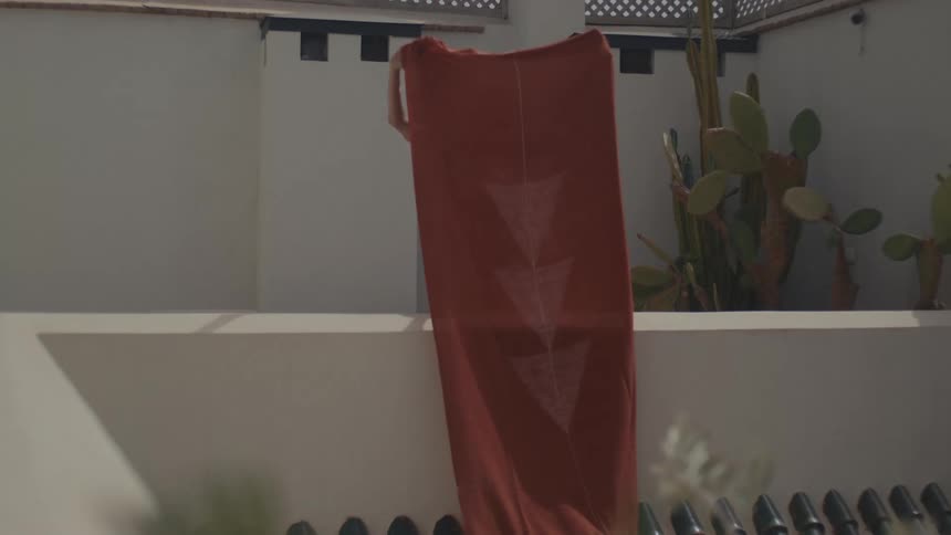 Woman sun drying a large towel outdoor