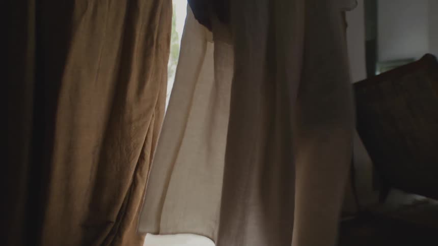 Person in a white dress opens the curtain and parades