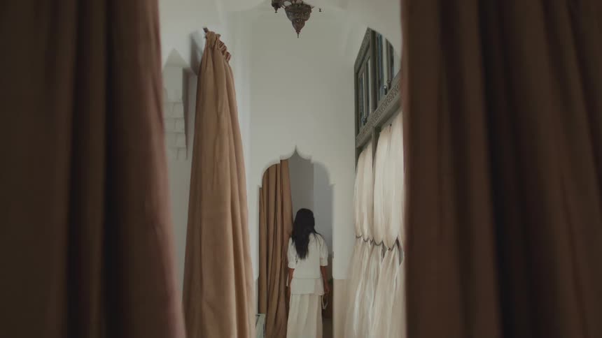 The woman walks and turns in the hallway