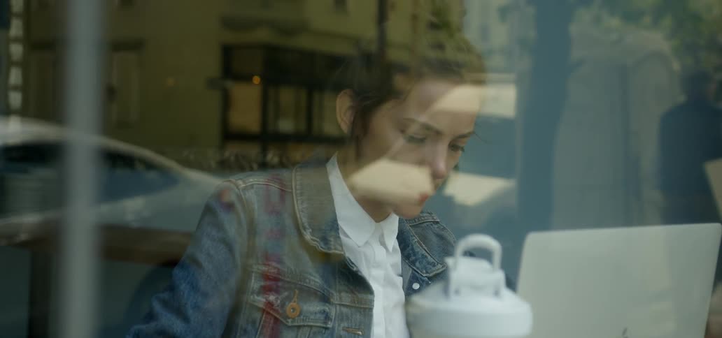 A woman sits with her computer in a restaurant