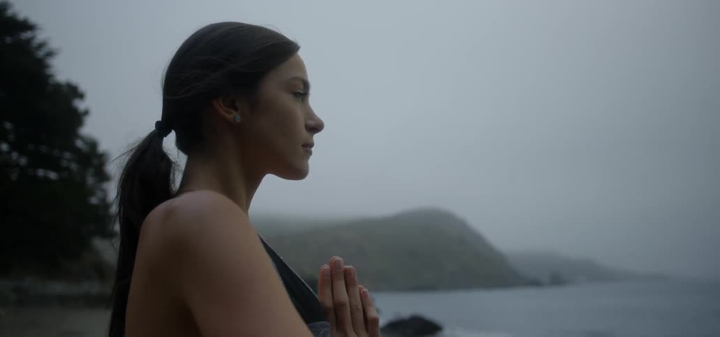 A woman does yoga on a beach