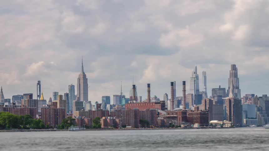Billowing clouds roll steadily over the midtown manhattan skyline in this dynamic timelapse casting shifting shadows on the iconic empire state building and the industrial smokestacks along the east river