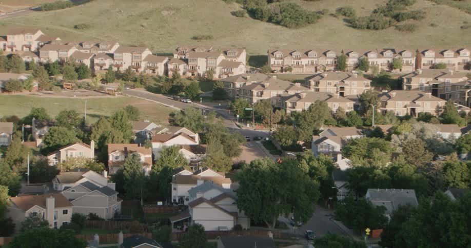 Car stops at an intersection in a residential neighborhood near the mountains