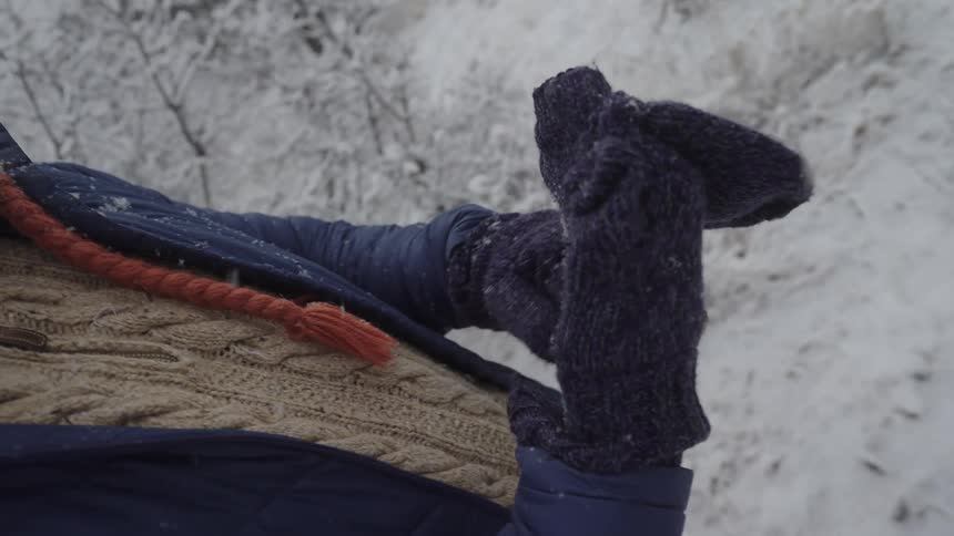 Person outdoors wearing gloves in a snowy environment