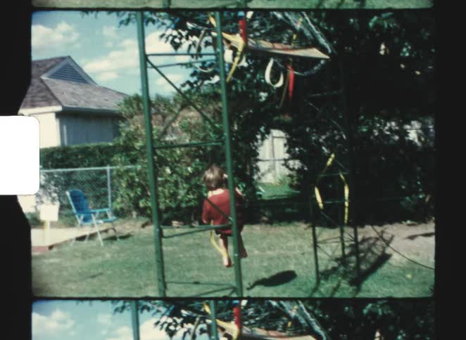 The boy is swinging around his yard