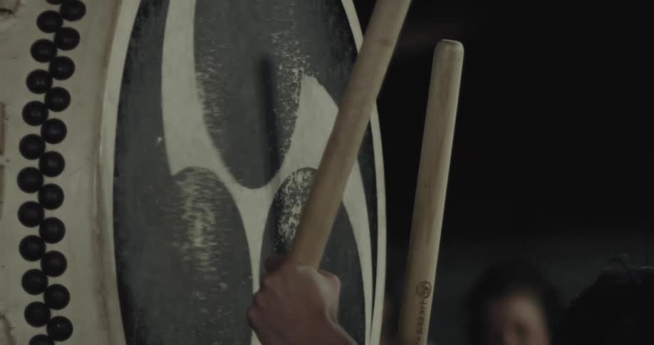 Hands with wooden picks striking a musical drum