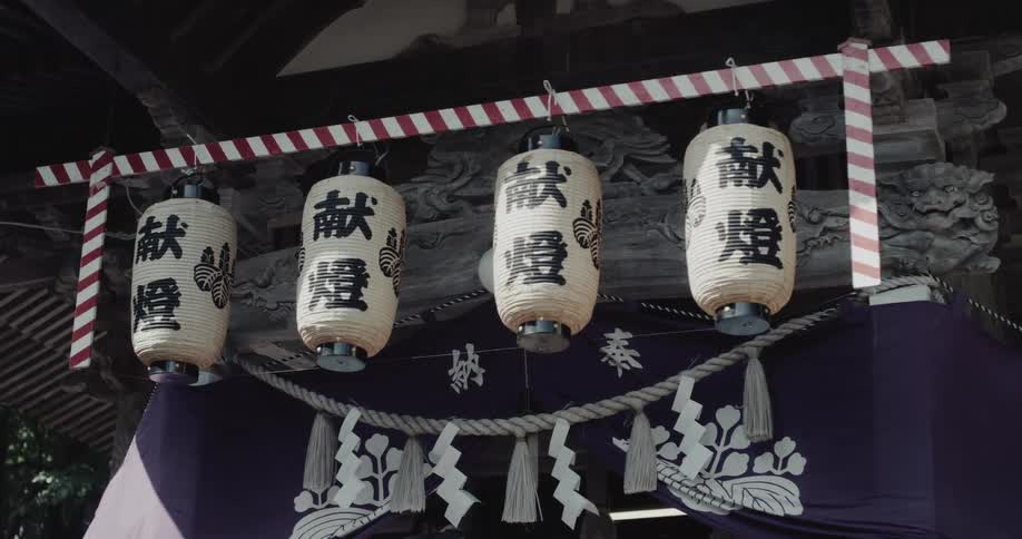 Lanterns hang above decorated entrance of japanese ceremonial structure