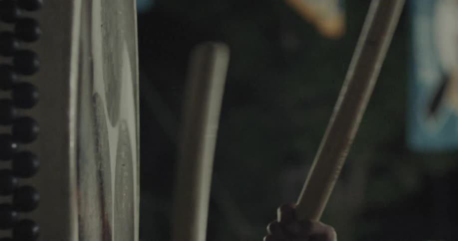 Drumsticks positioned near a drum in an indoor setting with blurred background