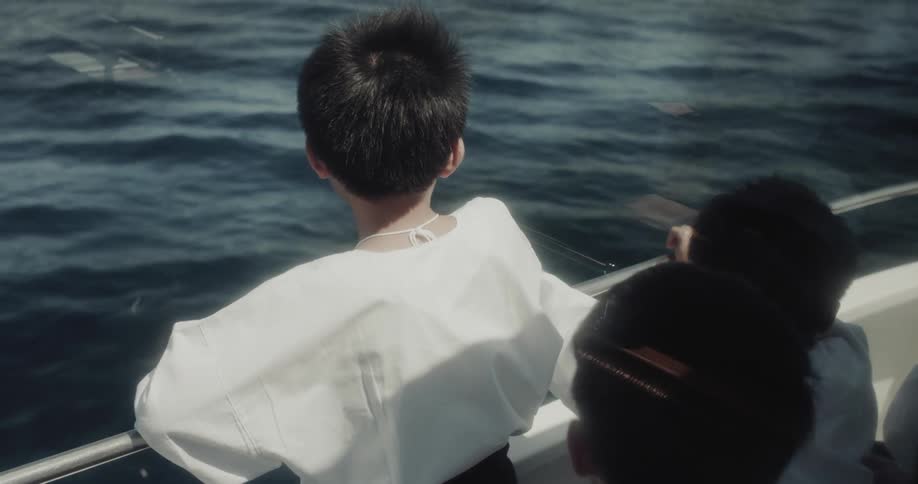Children observe calm waters aboard a boat