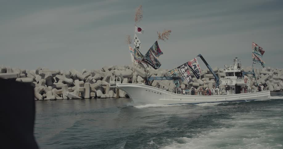 Japanese ship with crew members sailing across the ocean