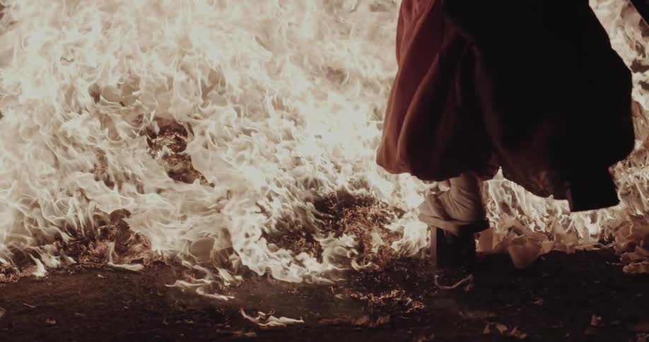 Pile of burning papers on dark surface with intense flames