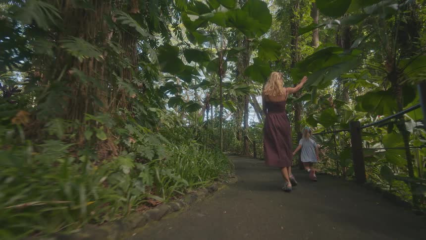 Mother and daughter skipping on a trail in the park