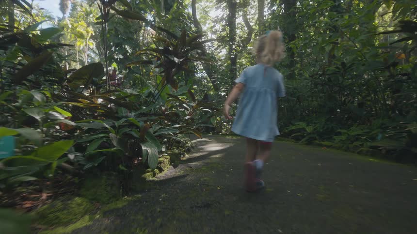 The girl runs and skips on the park trail