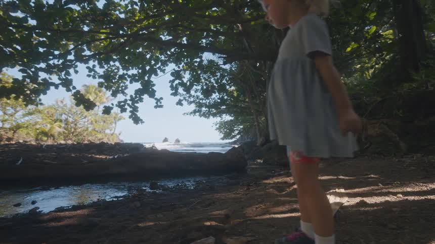 A child playing along the edge of a river