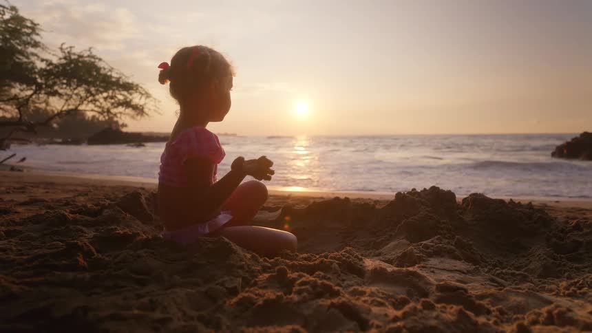 A child playing on a beach on a sunny day