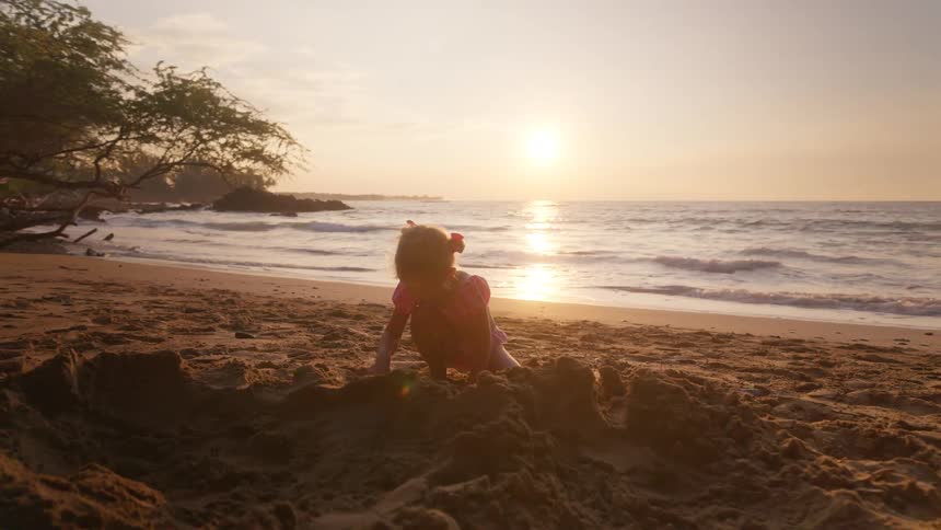 The girl is digging in the sand of the beach