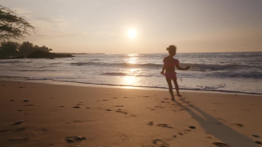 A little girl running around the beach