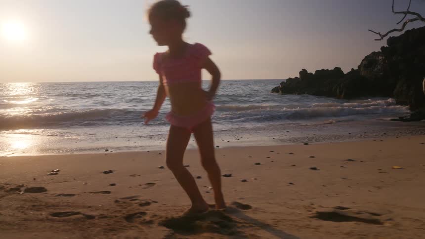 The girl runs in a circle on the beach