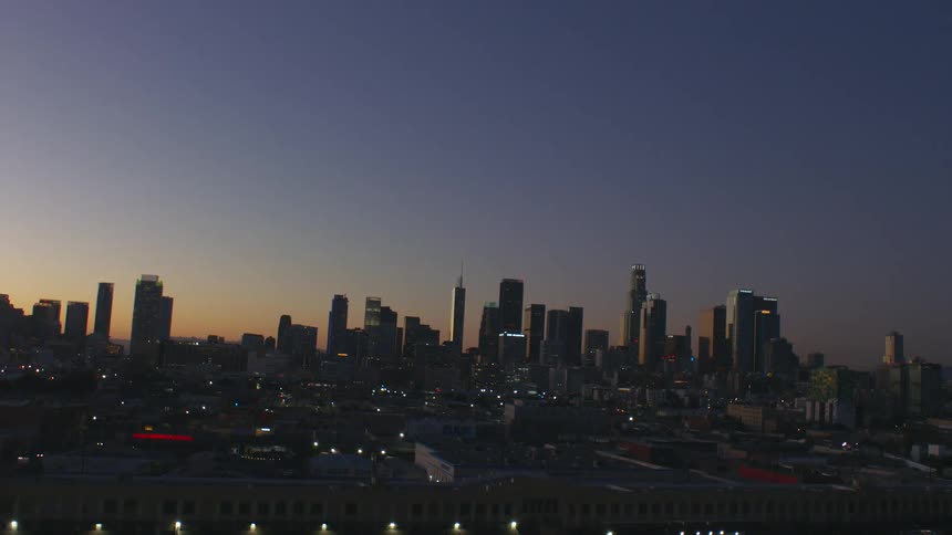 Downtown skyline stands against a red tinted sky in the evening