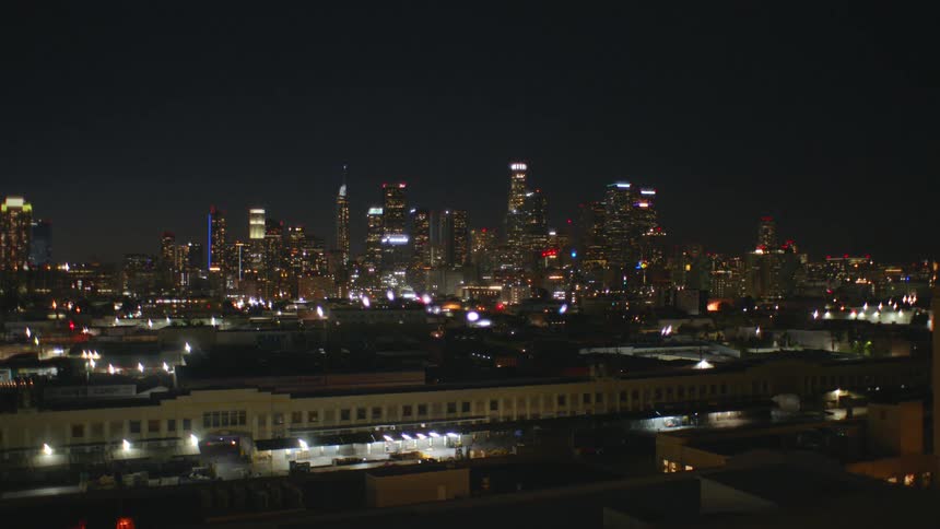 The city is brightly lit in the distance at night