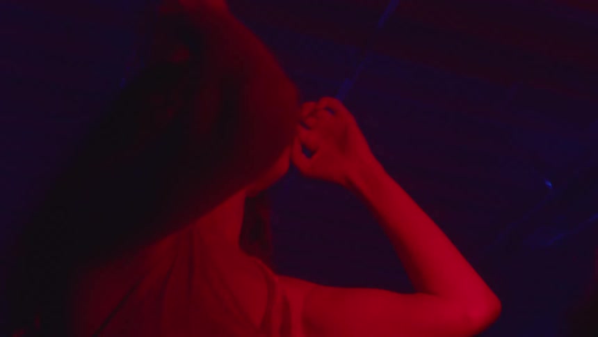 Person dancing under intense red lighting in a dark environment