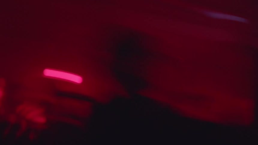 People gathered in an indoor space with diffused purple and pink lighting