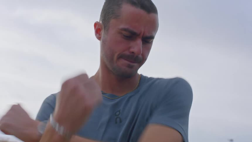 Man outdoors stretching his arm