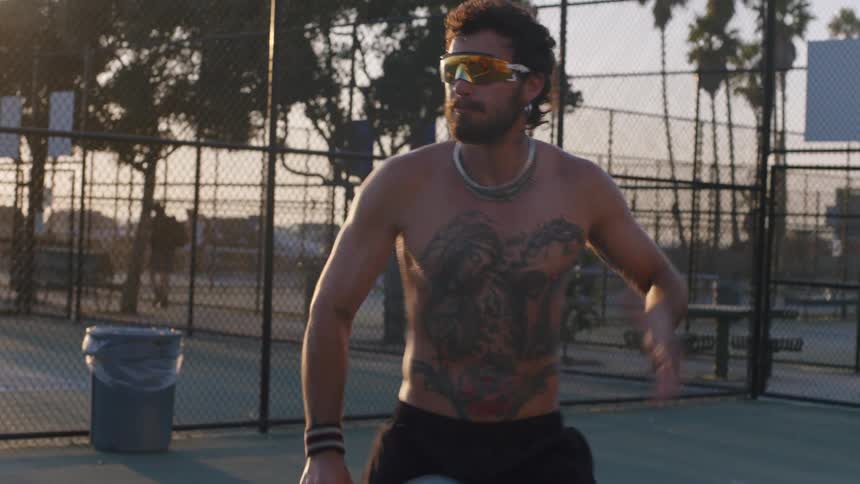 The man jumps and hits the tennis ball