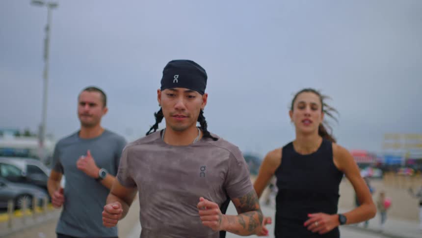 Group of three people running along the beach