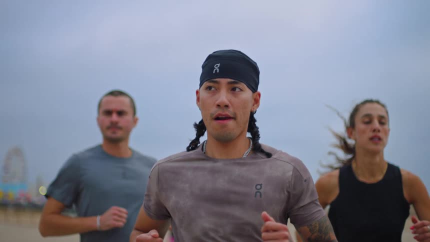 Three people with determined expressions running outdoors