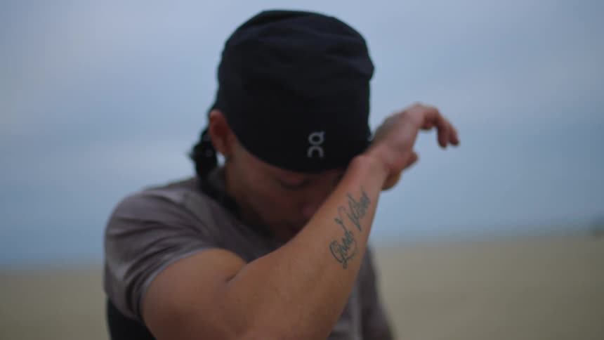 Man outdoors wiping sweat from his forehead