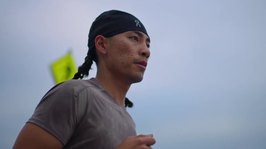 Man with a determined expression runs outdoors
