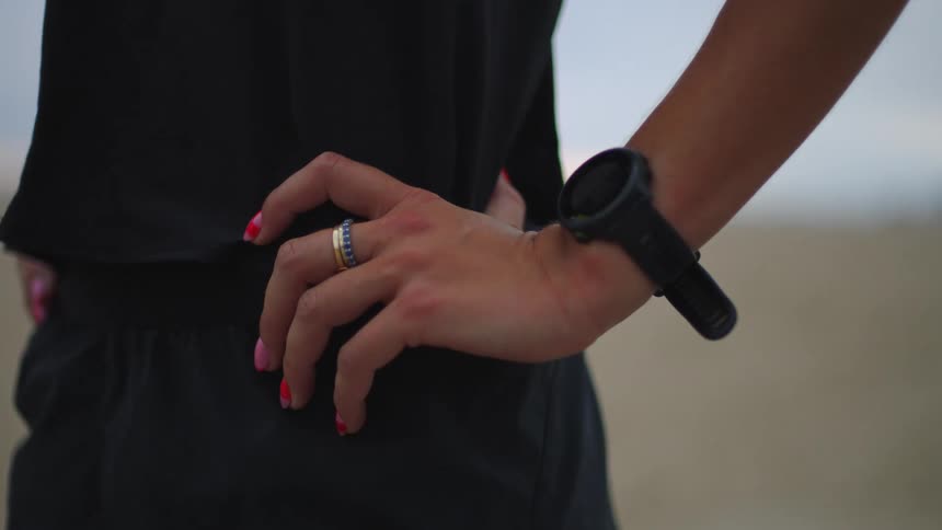 Close up of a young woman wearing a digital smartwatch while standing outdoors during daytime