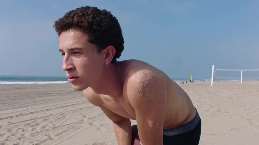 A man on the beach holding a football