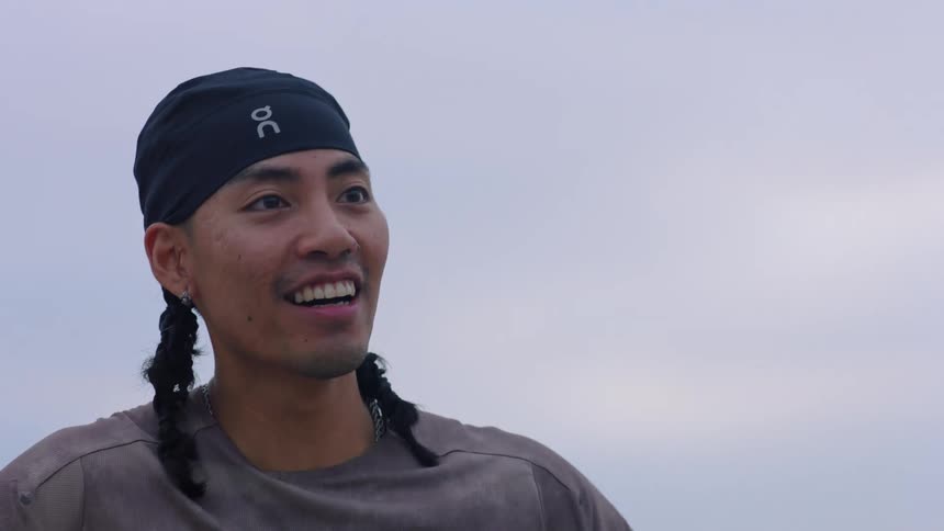 Man wears a headband and talks outdoors during a sports activity
